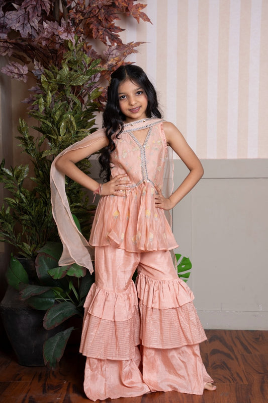 Peach peplum sharara set with dupatta and shimmer - layered ruffles for a festive - ready look. - Kirti Agarwal