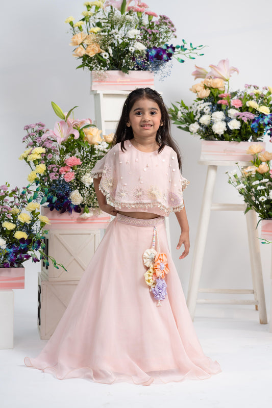 Elegant Pearl-Embellished Cape Top With Flowing Blush Lehenga And Statement Floral Latkan Detail