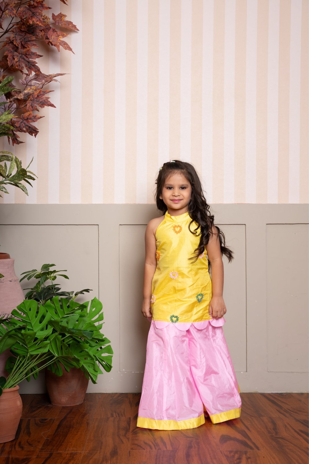 Charming yellow halter - neck kurti with scalloped hem and pink palazzo set, perfect for festive celebrations. - Kirti Agarwal