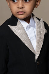 Classic black blazer with a champagne metallic - textured lapel, paired with matching pants and a crisp white shirt for a sophisticated formal look - Kirti Agarwal