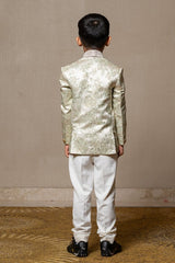 Elegant brocade suit jacket with floral patterns paired with crisp white trousers and a classic ivory shirt for a regal and sophisticated look. - Kirti Agarwal