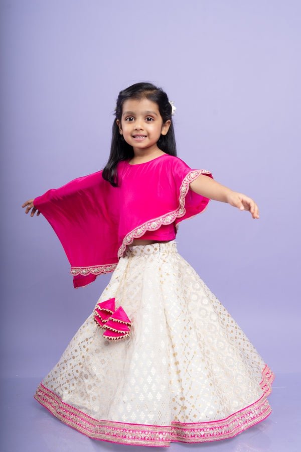 Elegant pink cape top with a white and gold lehenga, perfect for festive celebrations - Kirti Agarwal