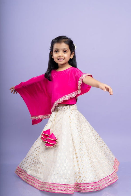 Elegant pink cape top with a white and gold lehenga, perfect for festive celebrations - Kirti Agarwal