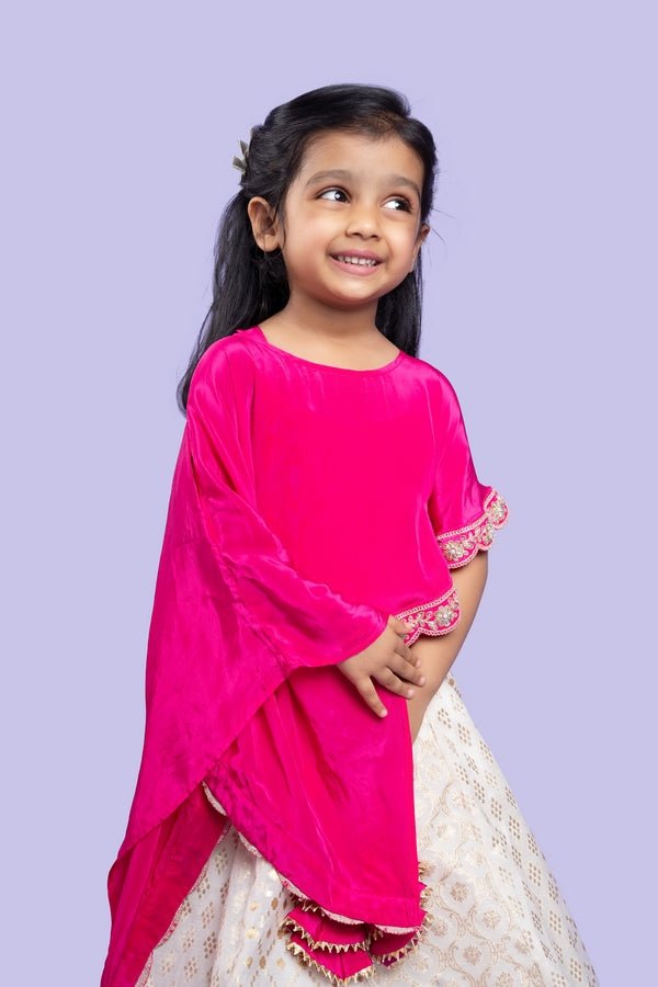 Elegant pink cape top with a white and gold lehenga, perfect for festive celebrations - Kirti Agarwal