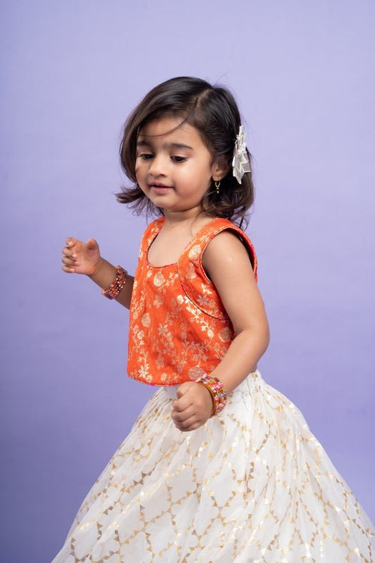 Festive orange brocade top with a golden - patterned white lehenga, perfect for celebrations - Kirti Agarwal