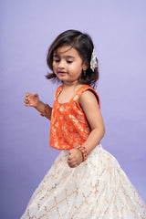 Festive orange brocade top with a golden - patterned white lehenga, perfect for celebrations - Kirti Agarwal