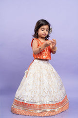 Festive orange brocade top with a golden - patterned white lehenga, perfect for celebrations - Kirti Agarwal