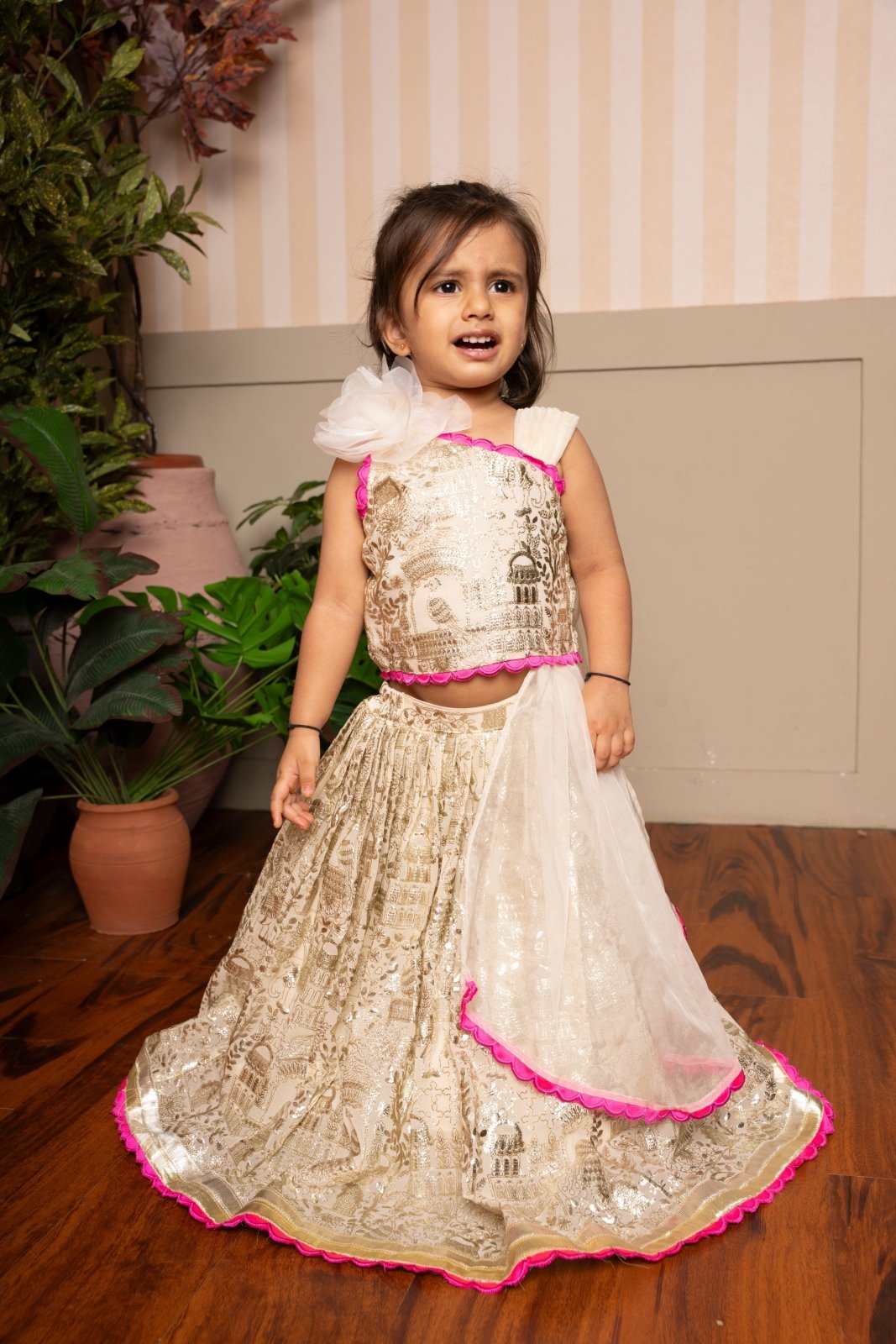 Graceful cream lehenga set with golden palace print and vibrant pink highlights for a festive royal charm. - Kirti Agarwal