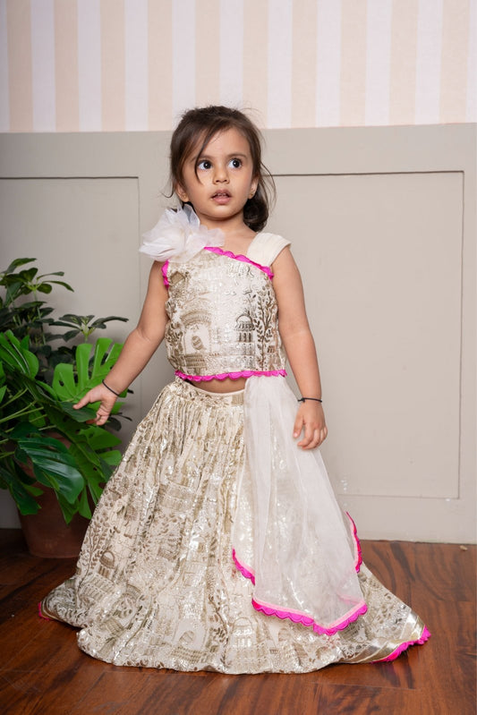Graceful cream lehenga set with golden palace print and vibrant pink highlights for a festive royal charm. - Kirti Agarwal