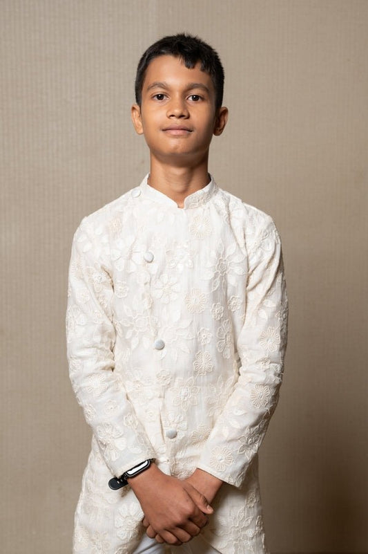 Intricately embroidered off - white bandhgala with matching white kurta and pants for an elegant traditional look - Kirti Agarwal