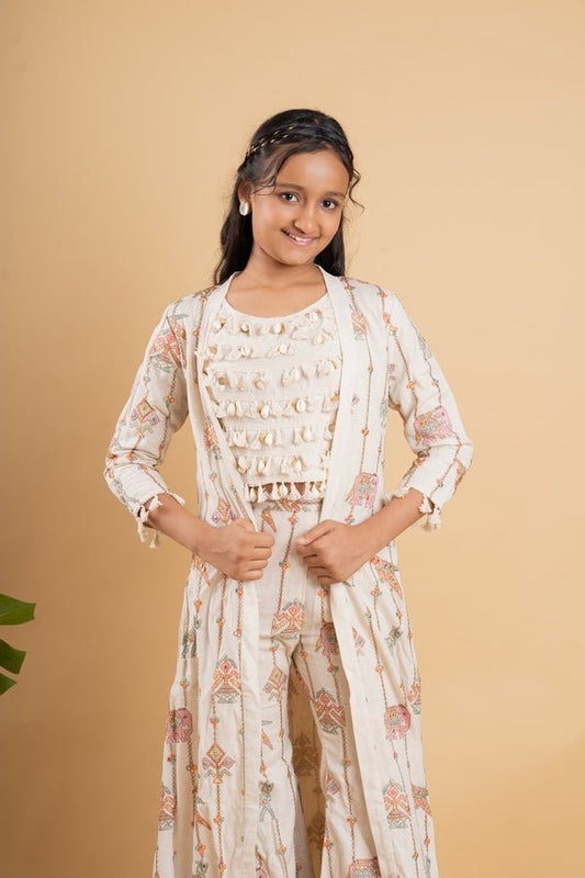 Vibrant ivory ensemble with colorful prints and tassel accents, perfect for a chic and playful look at any festive occasion. - Kirti Agarwal