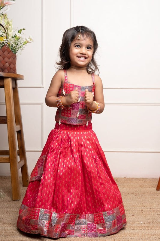 Vibrant red lehenga set with a multicolored patchwork blouse and golden motif print, perfect for festive occasions - Kirti Agarwal