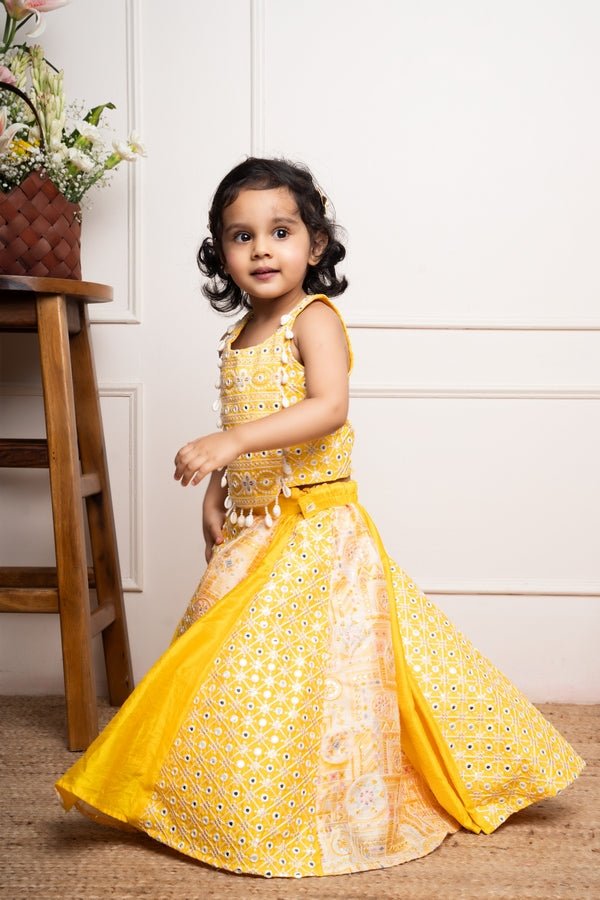 Vibrant yellow sleeveless dress with playful prints and tassel accents, perfect for festive celebrations and joyful occasions. - Kirti Agarwal